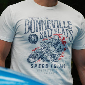 Man wearing a Bonneville Salt Flats white graphic t shirt standing in front of a classic car