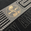 Load image into Gallery viewer, Close up of a Gold Shelby Cobra logo on a black graphic shirt