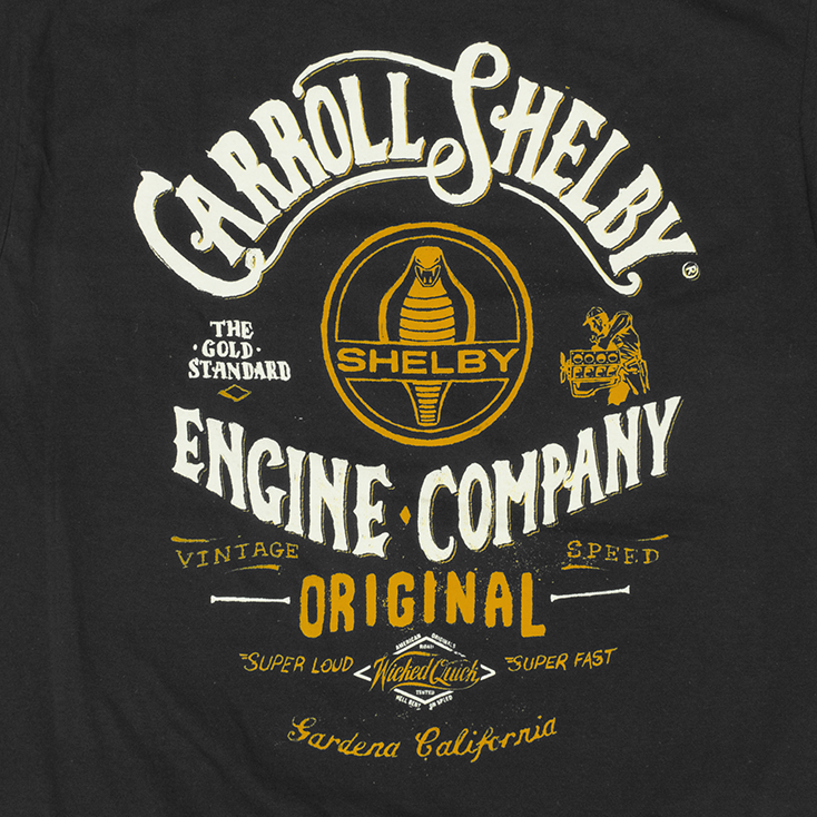 Close up of Shelby Engine Company black car shirt with white and gold graphic